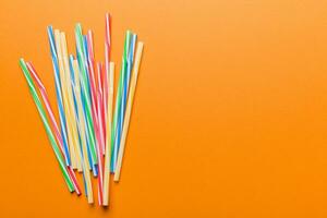 Heap of colorful plastic drinking straws on Colored background, flat lay. Copy Space for text photo