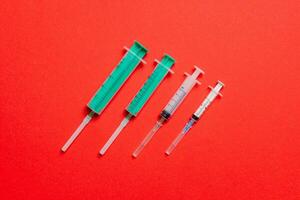 Top view of medical syringes on colorful background with copy space. Injection equipment concept photo