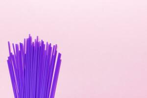 Heap of colorful plastic drinking straws on Colored background, flat lay. Copy Space for text photo