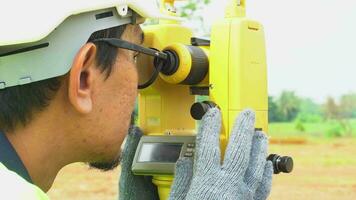 landmeter ingenieur met uitrusting theodoliet of totaal positionering station Aan de bouw plaats. video