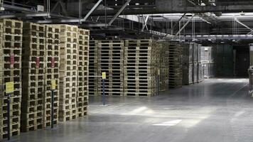 Warehouse with racks and shelves, filled with cardboard boxes, wrapped in foil on wooden pallets. Clip. Large and light warehouse, cargo storage in wooden boxes. Wooden pallets and cardboard boxes photo