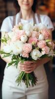 AI generated Florist holding a fresh bouquet of pink and white flowers in a flower shop. Ideal for wedding invitations, event flyers, or floral business advertisements. Vertical format. photo