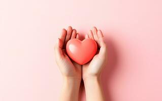 AI generated Two hands holding red heart over pink background with empty space for text. Health care, hope, life insurance and love concept. World heart and health day. Care home. Organ donor. photo