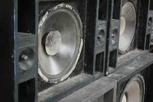 Several large music speakers sat unused, looking worn and dusty. photo