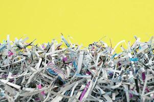 The shredded paper on light yellow background. photo