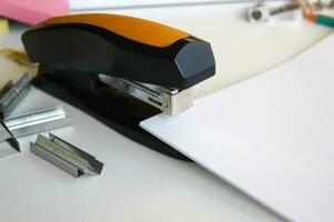 Classic black office stapler with documents. photo