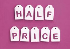 Nine white wooden tags with the word HALF PRICE. photo
