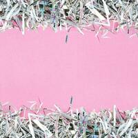 The shredded paper on light pink background. photo