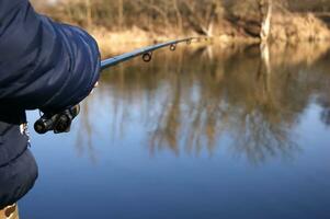 pescar varilla en el manos de un pescador en el lago. foto