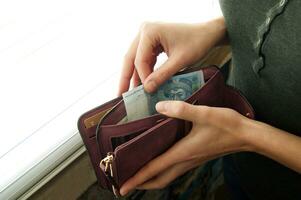 Women's hands choose the Ukrainian hryvnia in cash wallet. photo