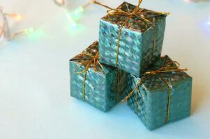 Navidad decoración para el Navidad árbol en el formar de pequeño brillante regalos en un azul antecedentes. foto