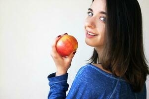 Happy slender woman holding apple isolated on a white background. photo