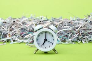 A white vintage clock in the foreground of 700 am on a light green background. photo