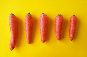 Natural organic carrot lies on yellow background. photo