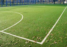 Green artificial turf football field in the park. White markings. photo