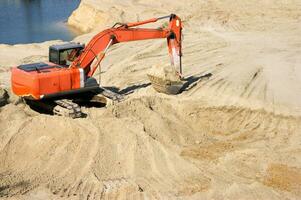 Orange excavator on a sand quarry. photo