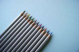 Color pencils lies on light blue background. Art concept photo