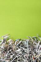 Shredded paper on light green background. photo