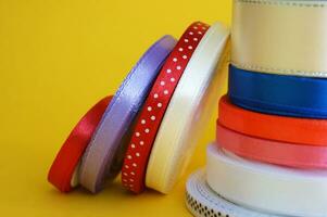 Spools of color ribbon on yellow background. photo