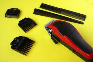 Hair clipper close-up on a yellow background with nozzles of different sizes. photo