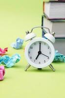 A white vintage clock in the foreground at 700 am on a light green background. photo