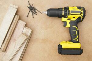 The yellow-black screwdriver on wood background, screws. photo