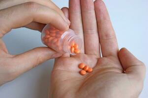 A man holds in his hand a portion of pills for treatment. photo