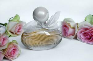 Perfume bottle with rose on a light background. photo