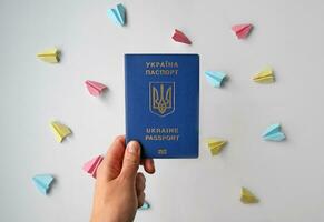 New Ukrainian biometric passport and colored paper planes on a white background. photo