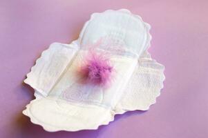 Menstrual pads on menstruation period calendar with on lilac background. photo