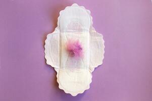 Menstrual pads on menstruation period calendar with on lilac background. photo