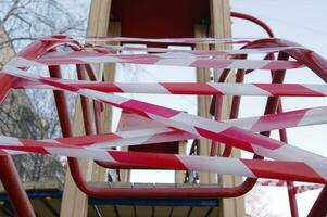 White and red barrier tape in a playground. photo