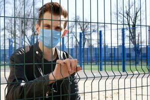 Image of the face of a young man in a mask to prevent the appearance of germs, toxic fumes and dust. photo