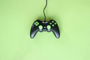 Joystick gaming controller isolated on green background. photo