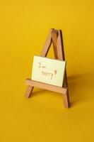 Sticker with sorry inscription on a mini easel. photo