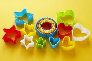 Plastic molds of multi colors for making cookies in the shape of a openwork circle, stars and hearts. photo