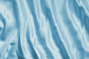 Closeup of rippled light blue silk fabric lines photo