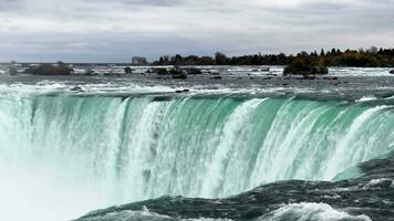 potente cascata, ipnotizzante Niagara cascate. un' a forma di ferro di cavallo cascata a pieno capacità su un' nuvoloso autunno giorno. video