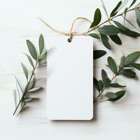 AI generated white blank tag with blank front realistic on a mockup template in a white wooden table with olive leaf branch photo