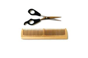 Wooden comb and scissors for a haircut isolated on a white background. photo