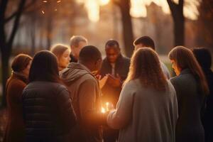 ai generado grupo de joven personas participación un iluminado vela en el otoño parque, un grupo de creyentes comprometido en un circulo de oración con suave, sereno Bokeh, ai generado foto