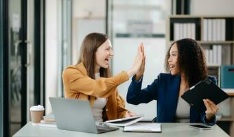 Happy businesspeople while collaborating on a new project in an office. two businesspeople using a laptop and tablet photo