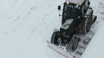 langzaam beweging beeldmateriaal van de tractoren schoonmaak omhoog de weg gedurende sneeuwval. seizoen video