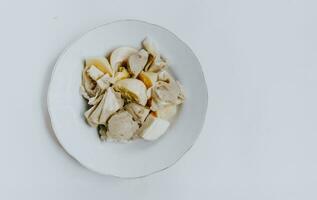 Top view of Siomay Bandung or steamed dumplings, traditional Indonesian street snacks without peanut sauce and soy sauce, served on a white plate. Copy space. Indonesian culinary food concept. photo