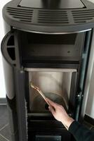 Man cleaning pellet stove with brush photo