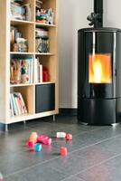 Pellet stove with some toys in front, with flames and library photo