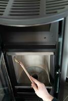 Man cleaning pellet stove with brush photo