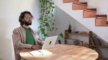 Man working with laptop from home stretching back to correct posture. Overworked Computer Concept. video