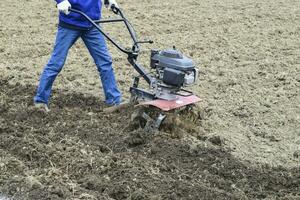 plantando patatas debajo el con operador a pie tractor foto