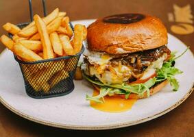 Full rustic beef burger with fries and fried egg photo